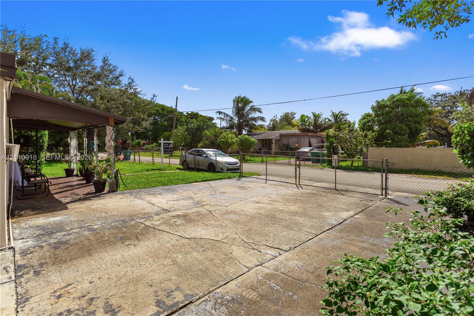 Concrete driveway, chain-link perimeter fencing, a