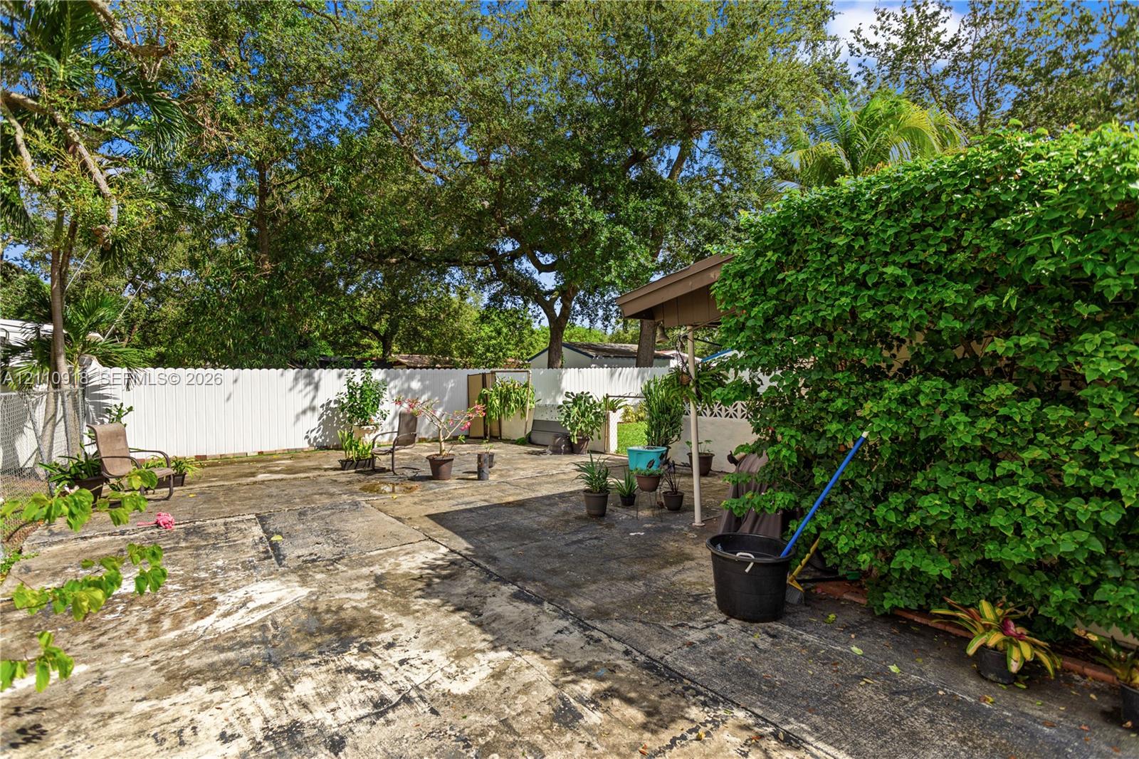 Fenced backyard featuring a concrete patio, a cove