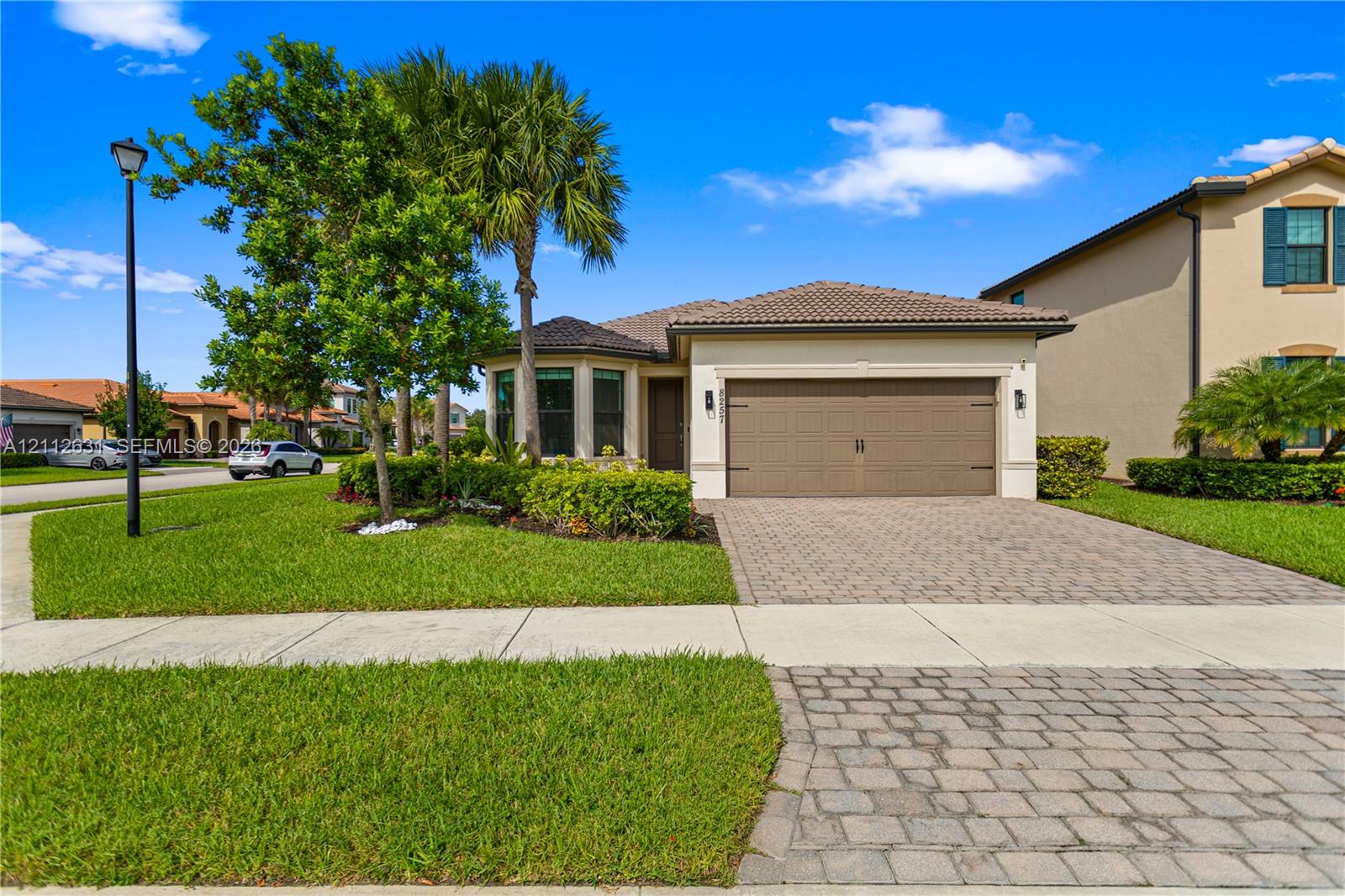 Stucco exterior with a tiled roof, paver driveway,