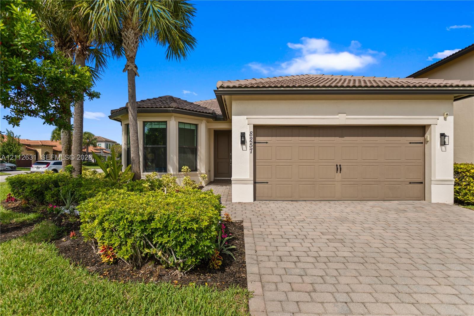 Stucco exterior featuring a tiled hip roof, multi-
