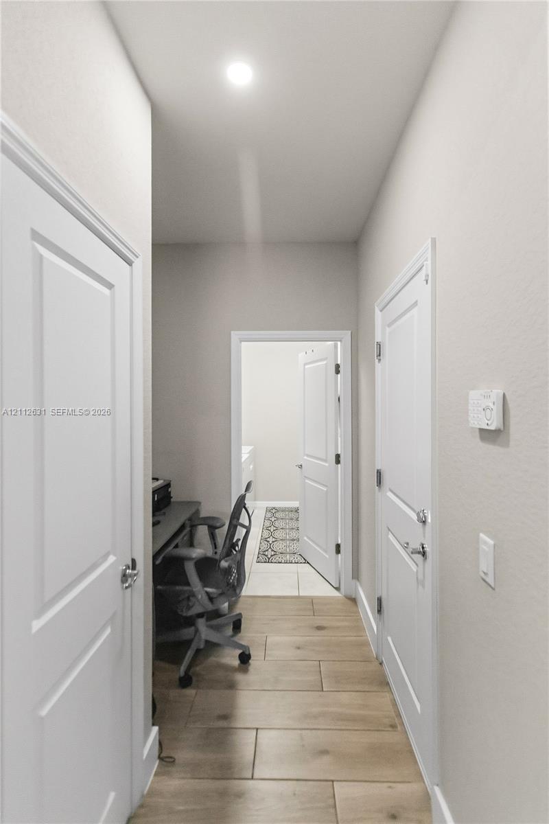 Hallway featuring wood-finish tile flooring, reces