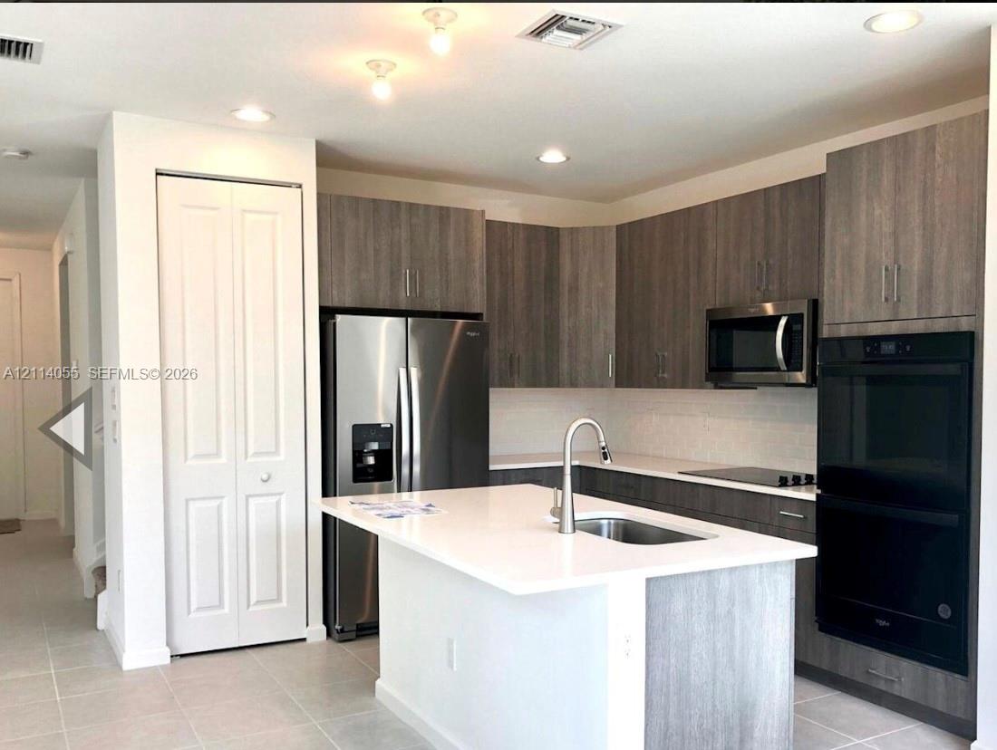 Kitchen featuring wood-finish cabinetry, quartz co