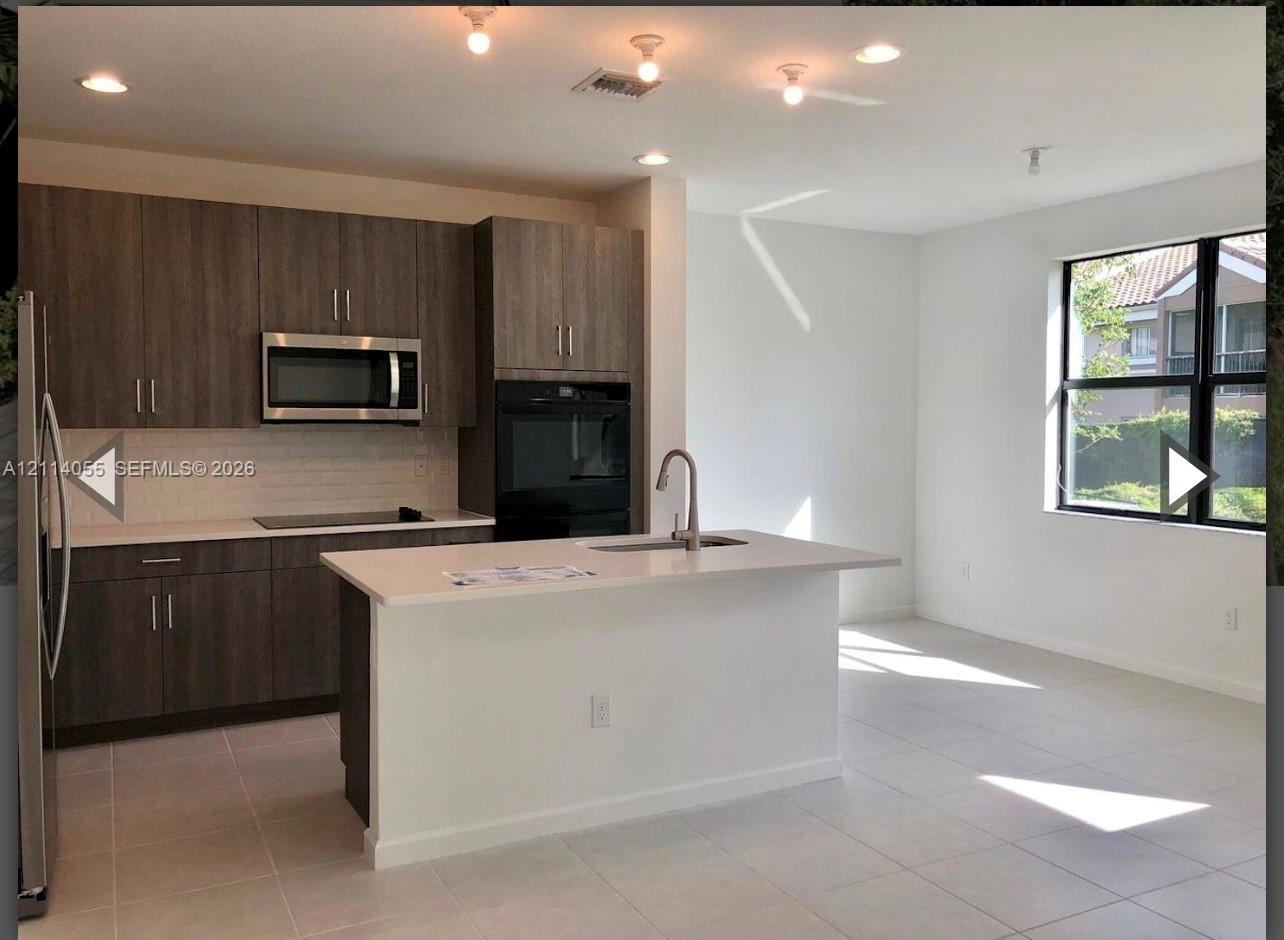 Kitchen featuring wood-finish cabinetry, a center