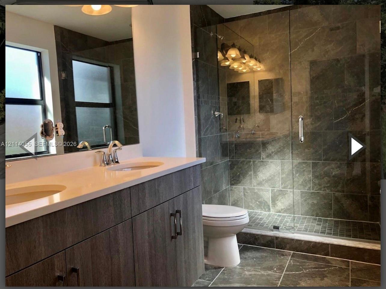 Dual-sink vanity with a white countertop and wood-